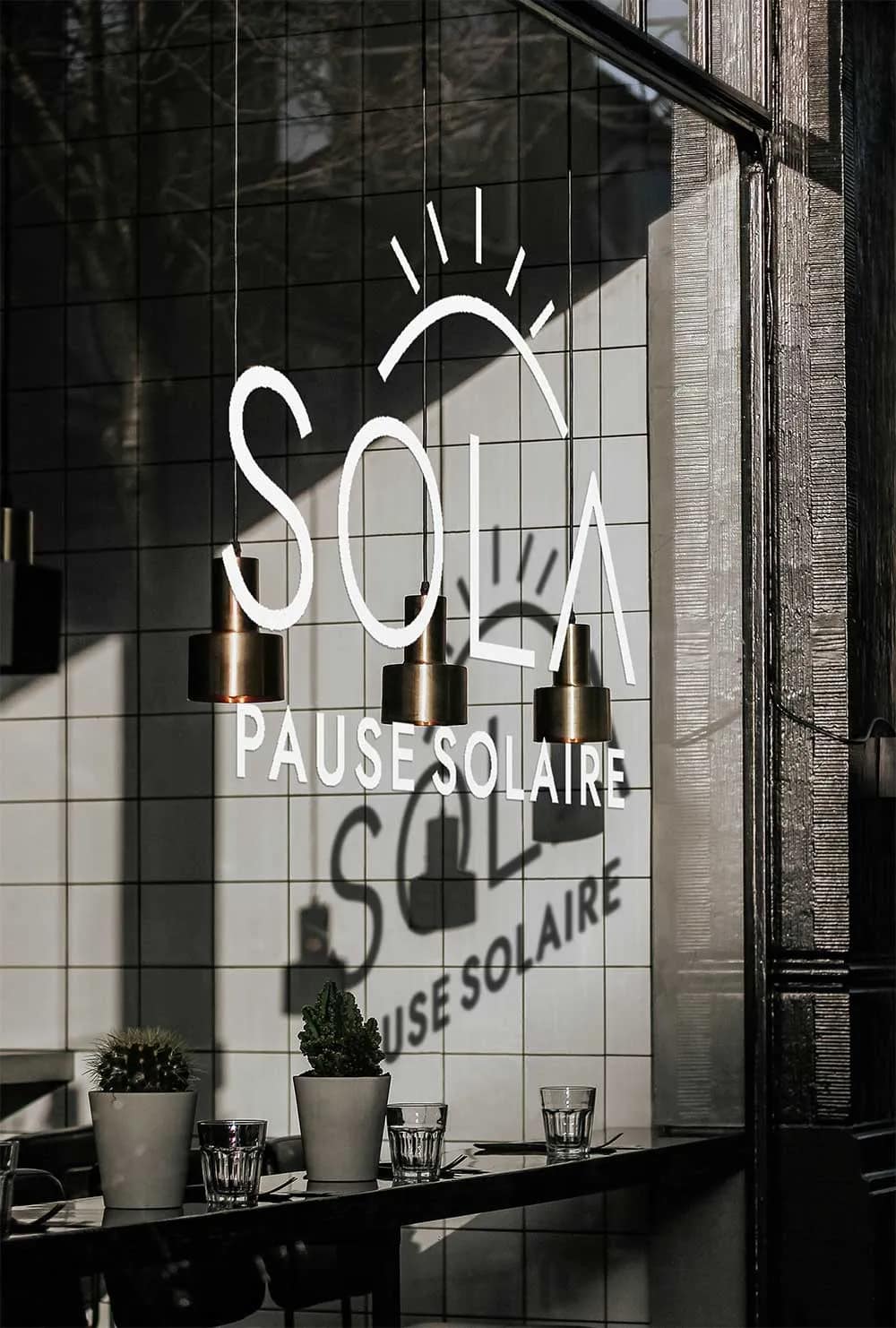 Mockup de la vitrine extérieure du café SOLA avec le logo sur la vitre.